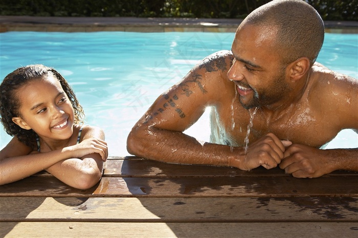 在游泳池里微笑的父子