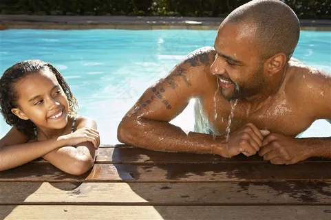 在游泳池里微笑的父子