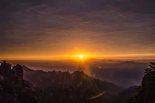 山顶远处天边日出风景图片
