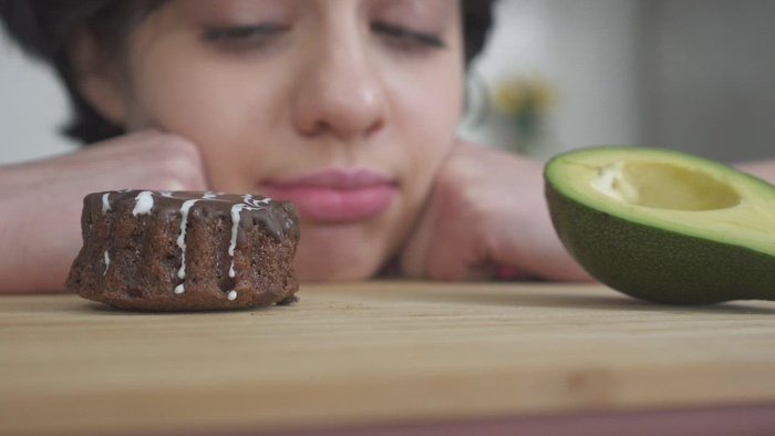 在坏食物和好食物之间做出艰难选择的女孩