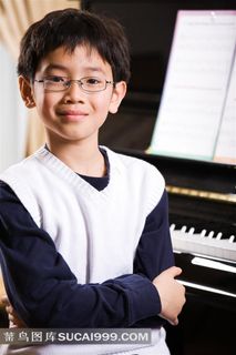 在钢琴旁边抱拳站着的小男孩