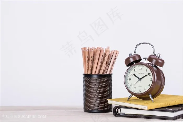 桌子上的铅笔闹钟书本文具图片