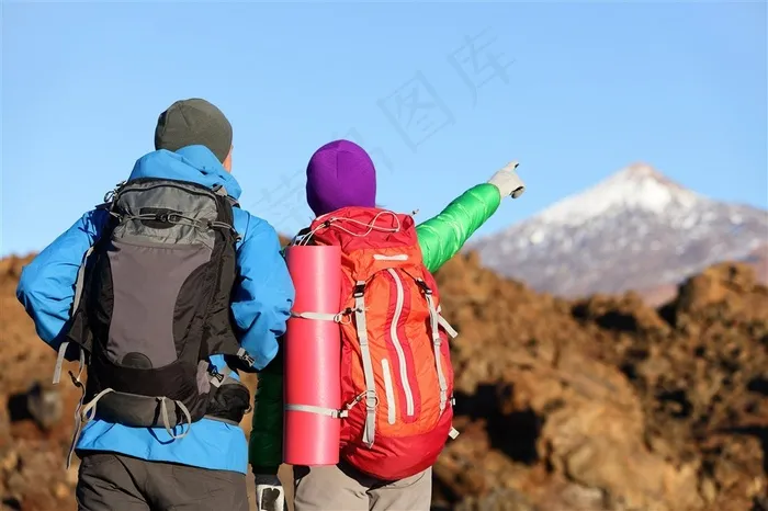 背着旅行背包手指着雪山顶部的情侣高清图片