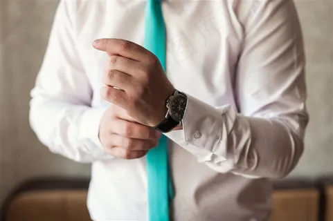 穿衬衣一手戴腕表的男士 穿衬衣一手戴腕表的男士