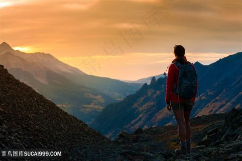 群山中伫立的红衣背包男子高清