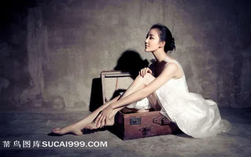 坐在箱子上的婚纱美女素材