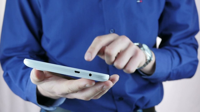 穿着蓝色衬衫的男人使用平板电脑