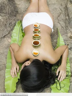 趴在岩石上做竹筒SPA养生的女性