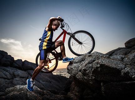推着自行车翻越障碍的男子