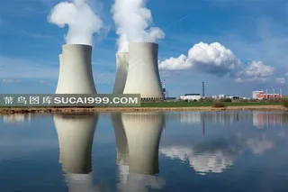 蓝天下的冒烟的工业烟囱和湖面的倒影高清图片