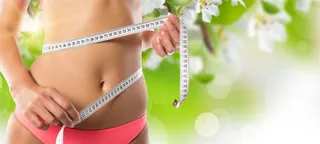 大自然背景上拿着皮尺丈量腰围的女性减肥高清图片