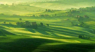 春日阳光下绿色连绵山脉草坪