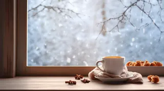 冬日窗外的雪景和窗台的咖啡摄影图