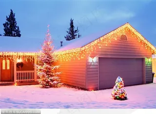 傍晚装饰着彩灯的房屋和屋前的圣诞树