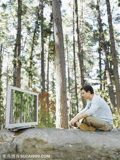 广告创意素材-坐在石头上看电视的男人