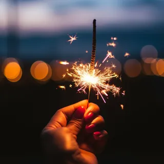 夜晚手拿着点燃的烟花仙女棒闪光摄影图