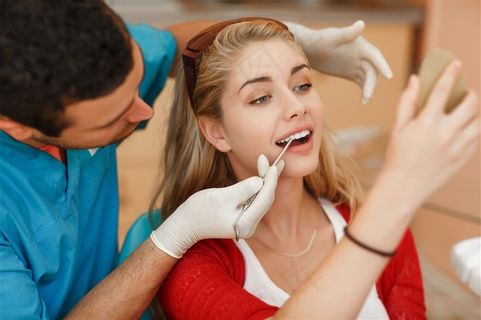 正在用工具为女患者看牙的医生