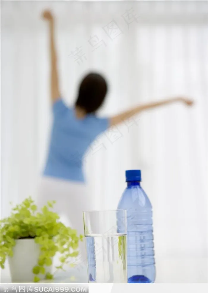 站在窗户边做伸展运动的年轻女人