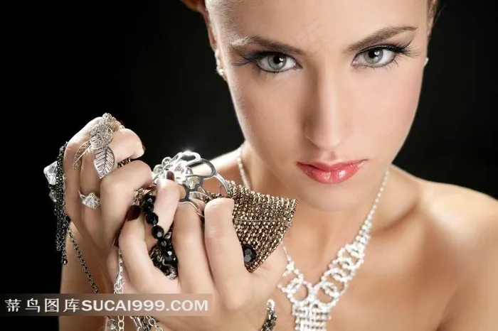手持项链珠宝的美女图片