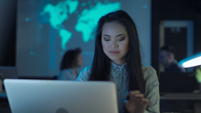 一位女士在笔记本电脑前喝咖啡