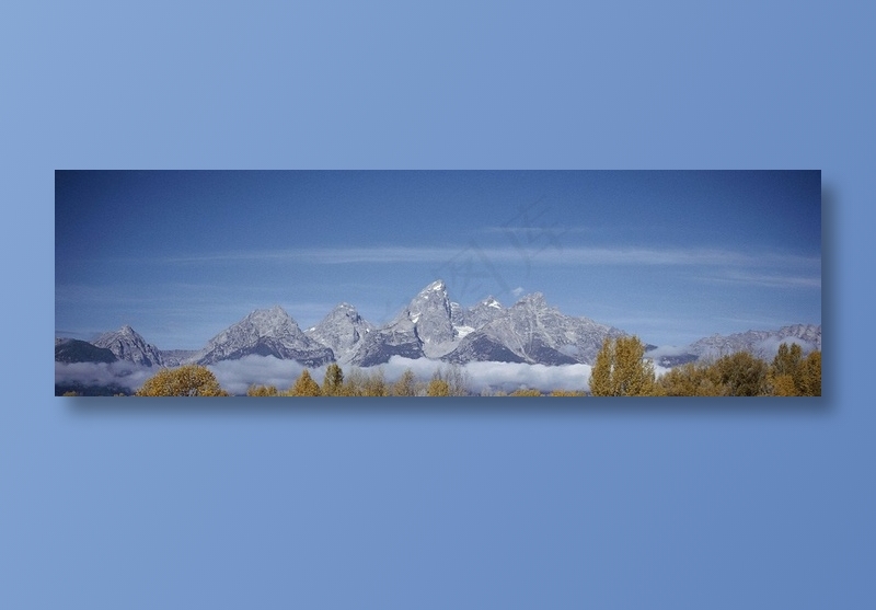 蓝天下云层上的雪山山峰