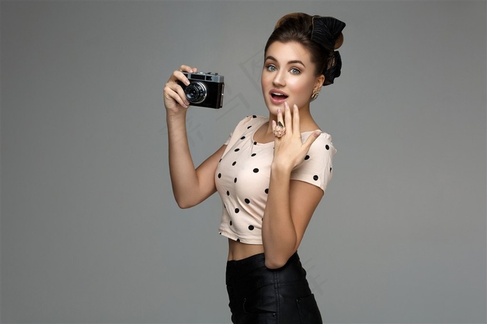 拿着相机抚摸脸颊的美女高清图