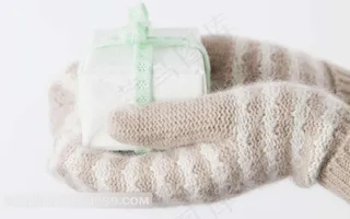 戴手套的手捧白色礼物盒