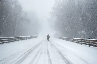 冬天雪景公路行走的人摄影图