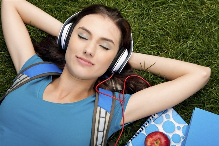 躺着草地上听音乐的美女