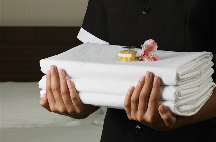 拿着被单的酒店服务人员