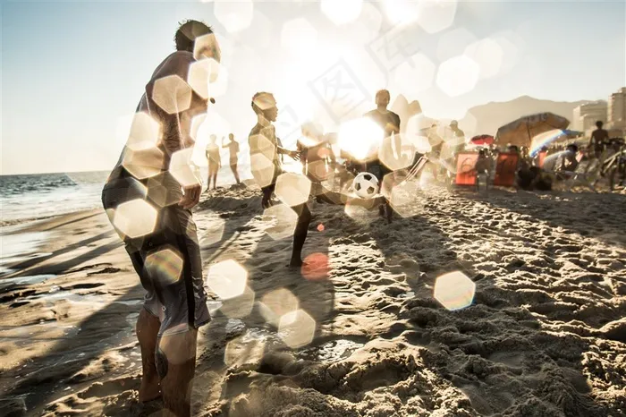 阳光照耀下在海边踢足球