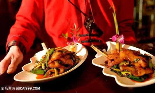 双手端着四川名菜回锅肉上菜