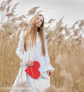 蒲苇中拿着红色爱心的欧美美女心型图片