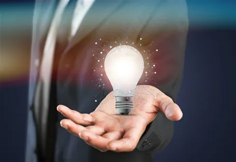 商务人士手掌上发光的灯泡高清图片