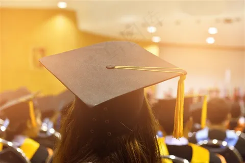 戴着黄色流苏博士帽参加毕业典礼的学生高清图片