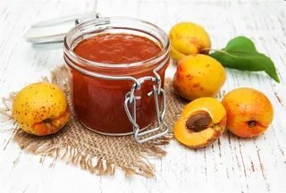 白色木头上的黄桃和果酱