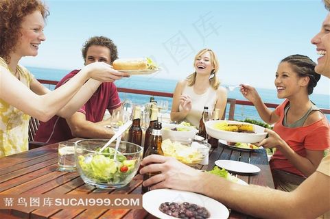 海边度假聚餐多个年轻人干杯合影