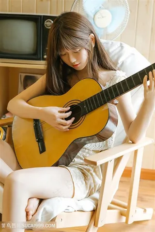 坐在椅子上弹吉他的高清美女图片