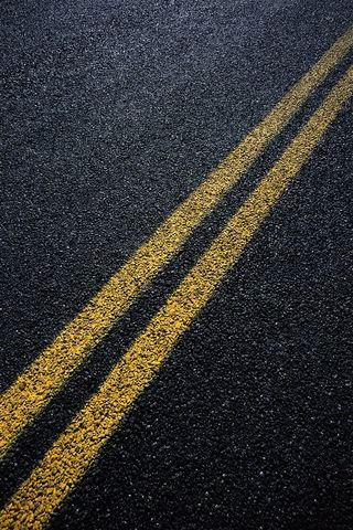 有双黄线的柏油路面高清摄影图