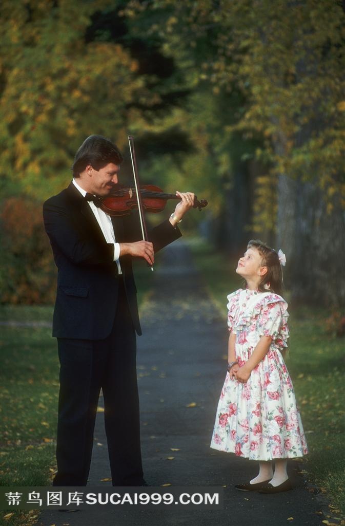 在林荫道上拉小提琴的父女