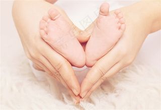 母亲手和婴儿脚组成的爱心