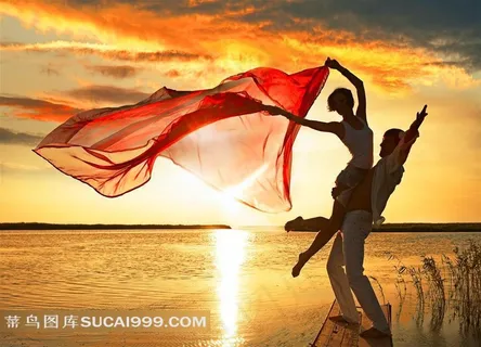 黄昏海边舞动红丝巾的浪漫情侣