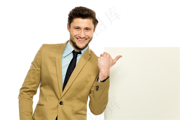 穿着西装用大拇指指着广告牌的男士高清图片