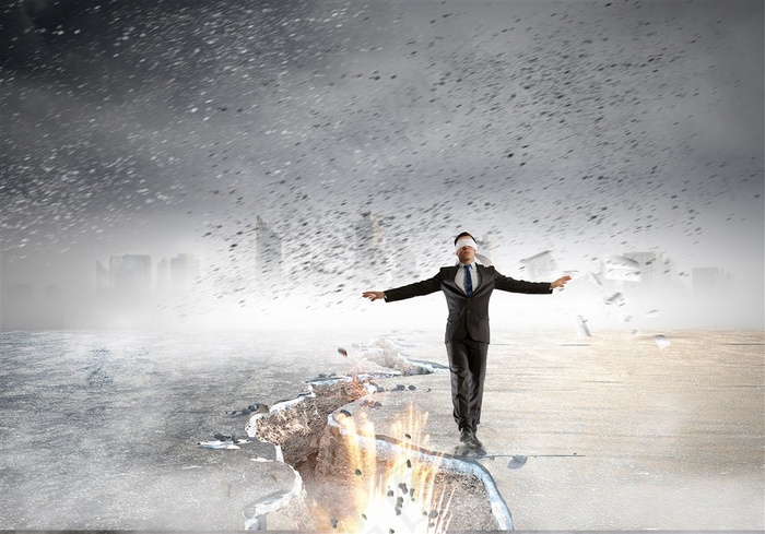 蒙着眼镜行走在悬崖裂缝边缘的商务人士高清图片