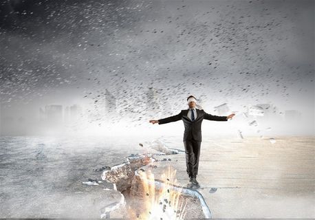 蒙着眼镜行走在悬崖裂缝边缘的商务人士高清图片