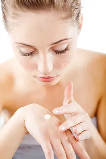 低头涂抹护肤品的美女人物高清摄影图片 低头涂抹护肤品的美女人物高清摄影图片