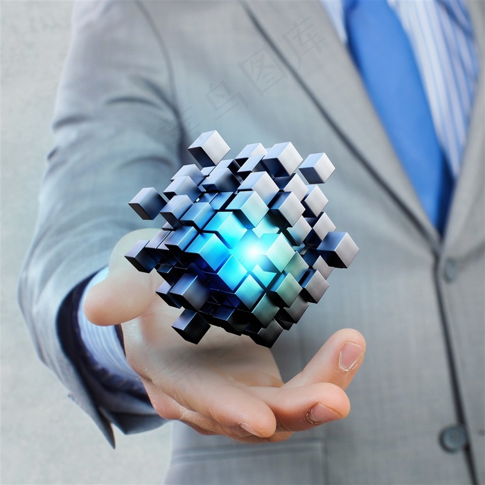 灰色西装男子的单手中的蓝色魔方高清摄影图片