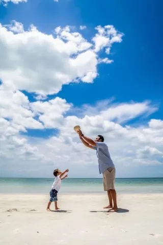 父子海边沙滩玩耍图