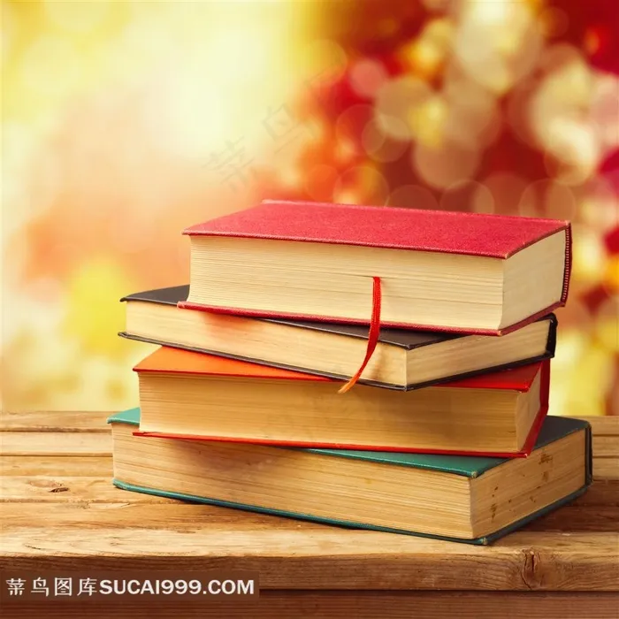 暖色背景前木桌上的一叠书图片素材书本图片