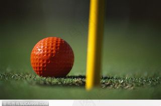 洞口边的橙色高尔夫球